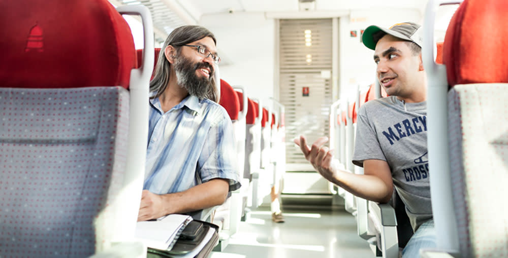 Two men talking on the MetroRail.