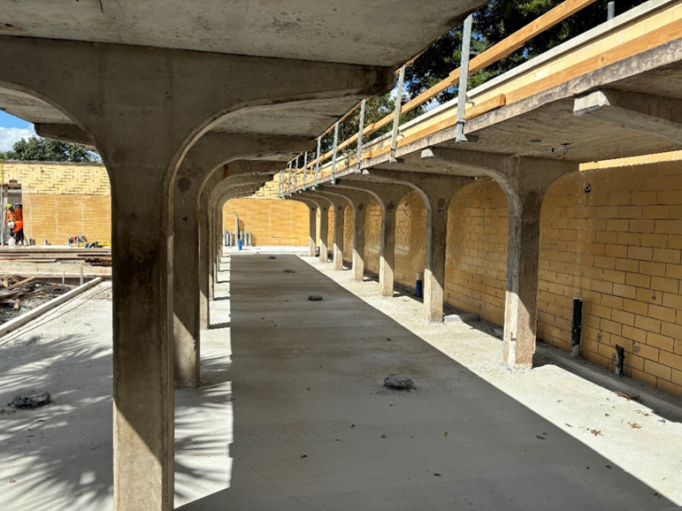 Photo showing the Men’s Shower & Dressing Courtyard area after installation of concrete foundation and brick pavers.