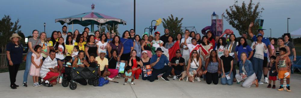 A large group of people posing at a park outside.