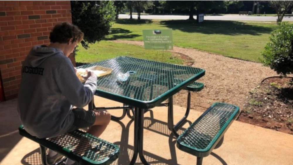 person sitting outside at a new metal table
