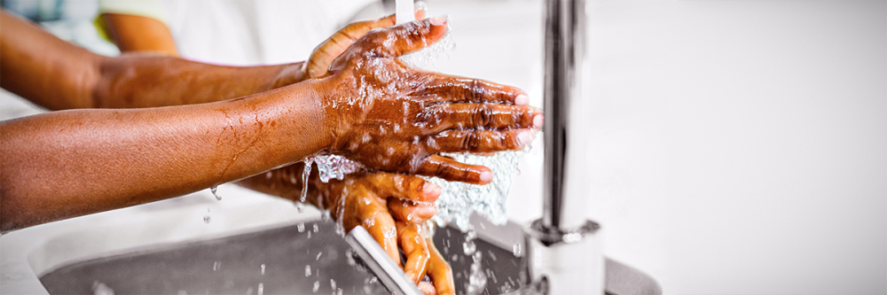 african-american-siblings-wash-hands-together-under-kitchen-faucet