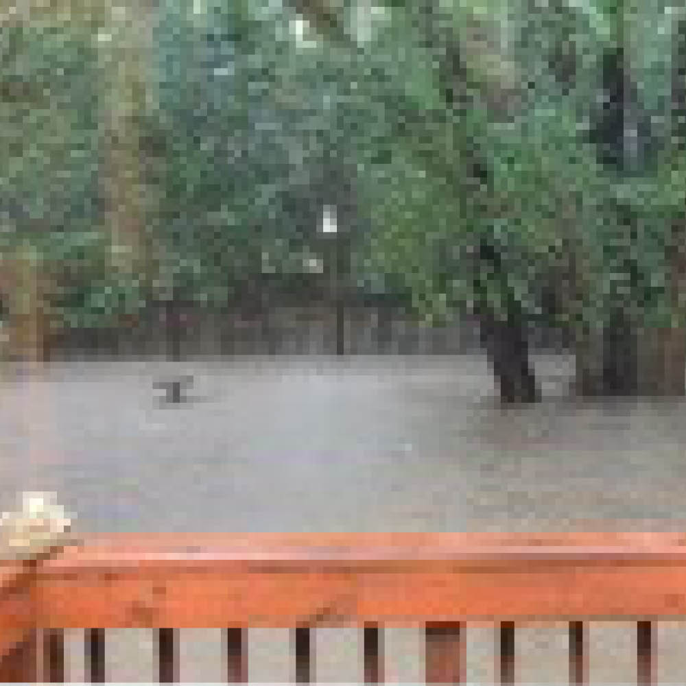 Water flooding a backyard near a deck