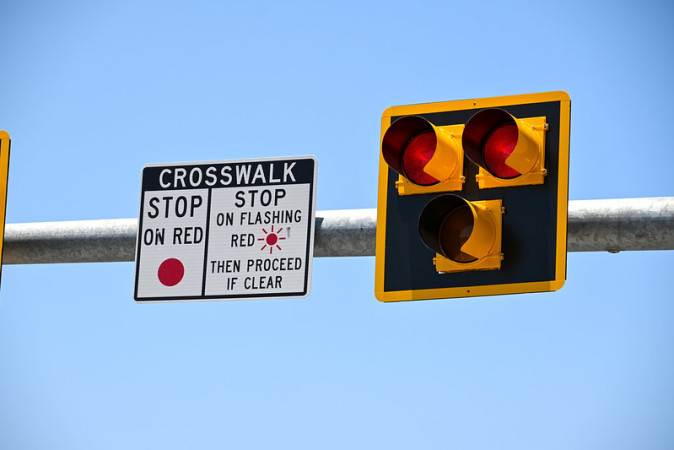 Pedestrian hybrid beacon shows three lights that flash red when a pedestrian is crossing