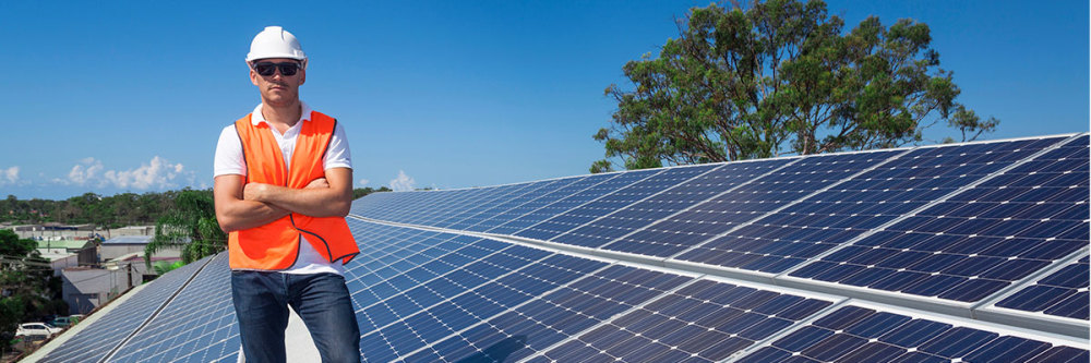 Contractor-stands-on-roof-next-to-solar-panels