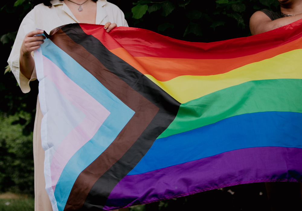 Two people holding a pride flag