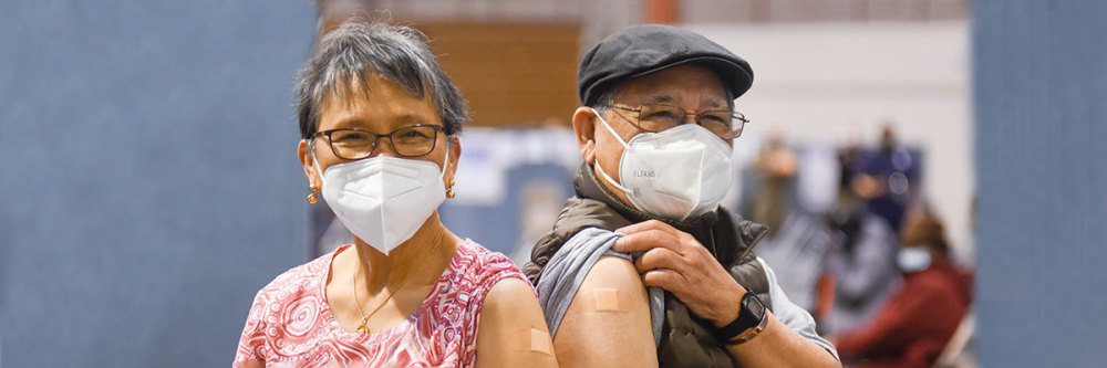 older-asian-man-and-woman-show-off-vaccination-bandaids-on-arms