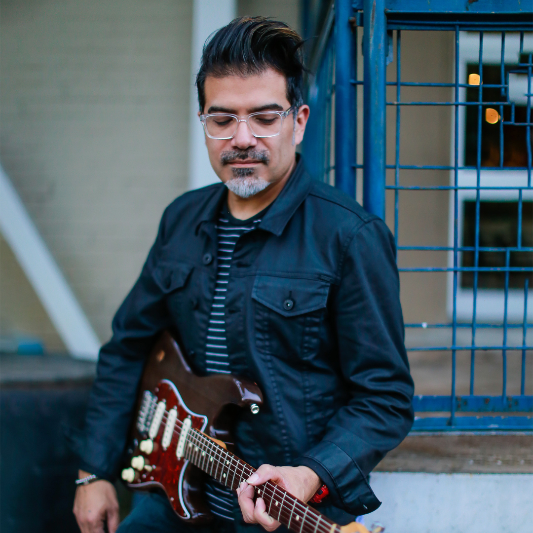 Musician Adam Zuniga playing guitar