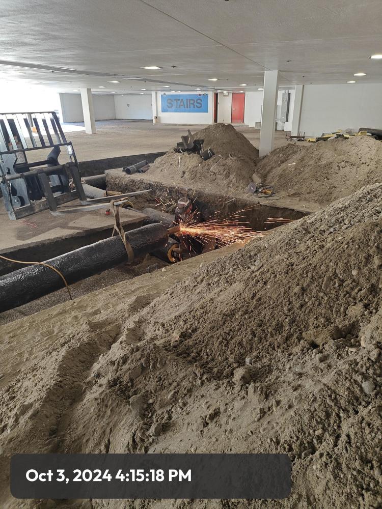 Welding taking place on new steam pipes in the parking garage of the Fairbanks Regional Office Building.