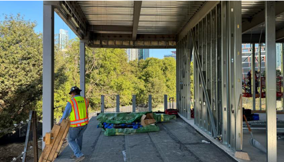 Exterior corridor being waterproofed on second floor.