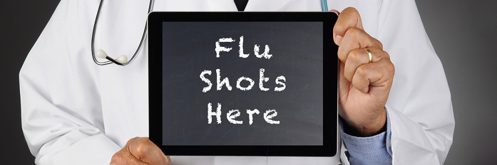 doctor-holdiing-iPad-displaying-message-Flu-Shots-Here