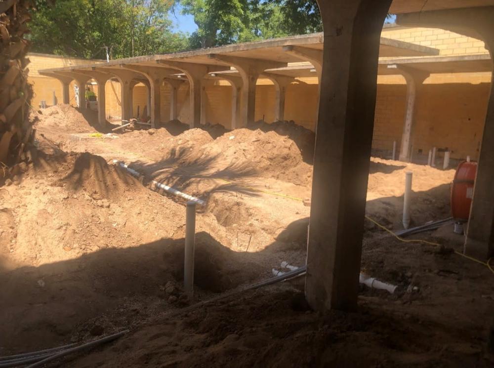 Men’s Shower & Dressing Courtyard with ongoing installation of water and wastewater plumbing lines.