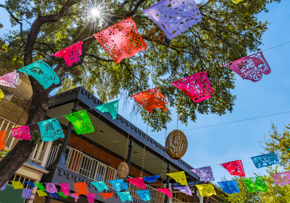 Papel picado hanging up with the sky in the background