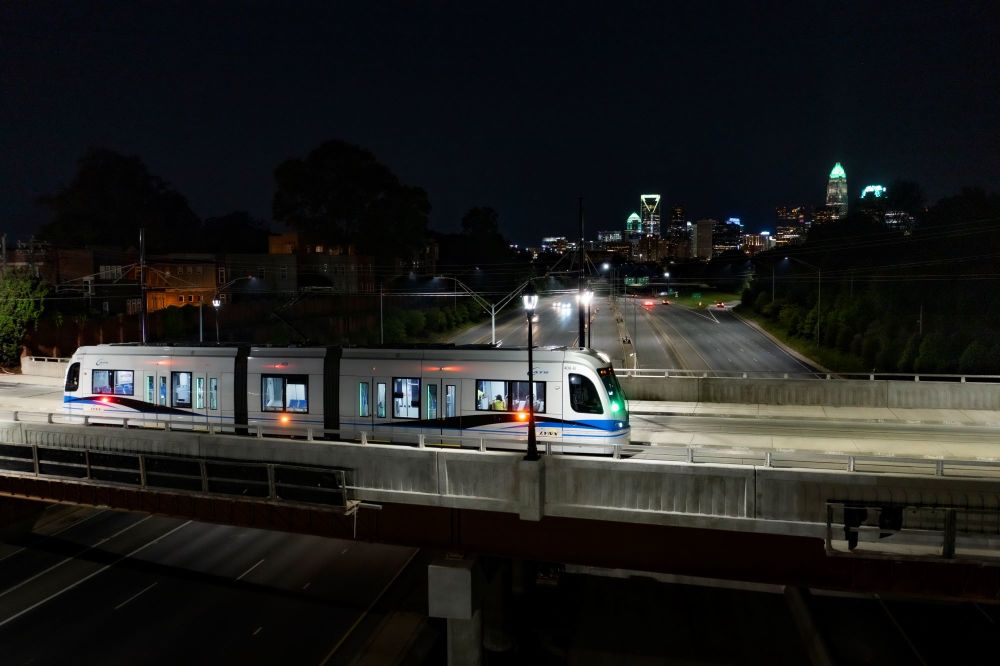 New streetcar traveling over the Hawthorne Lane bridge with the Charlotte skyline in the distance