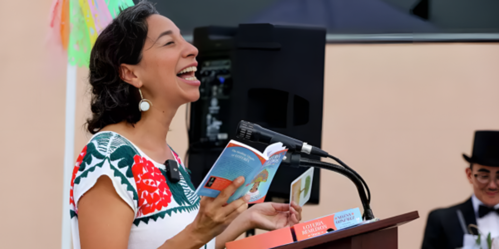 Artist Xelena reading poetry at microphone