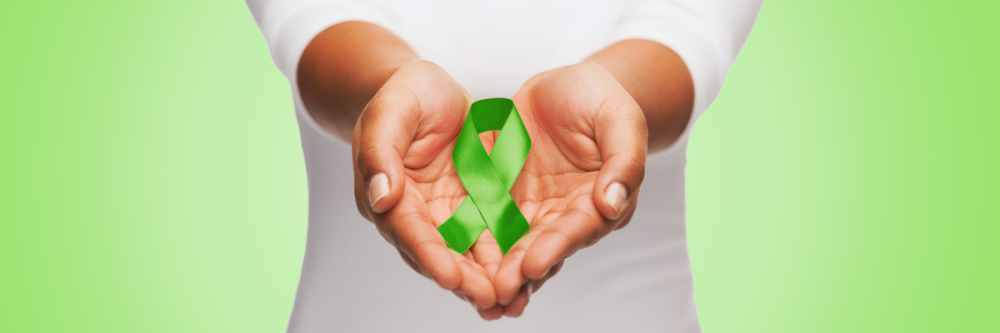 Hands holding green mental health ribbon with green banner