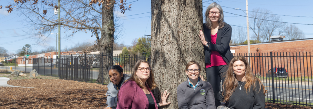 Women of Landscape Management Pose with Tree