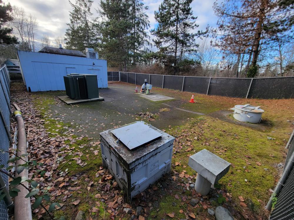 The Lakeland Hills Pump Station is a rectangular gray facility located behind a fenced area in Roegner Park in Auburn.