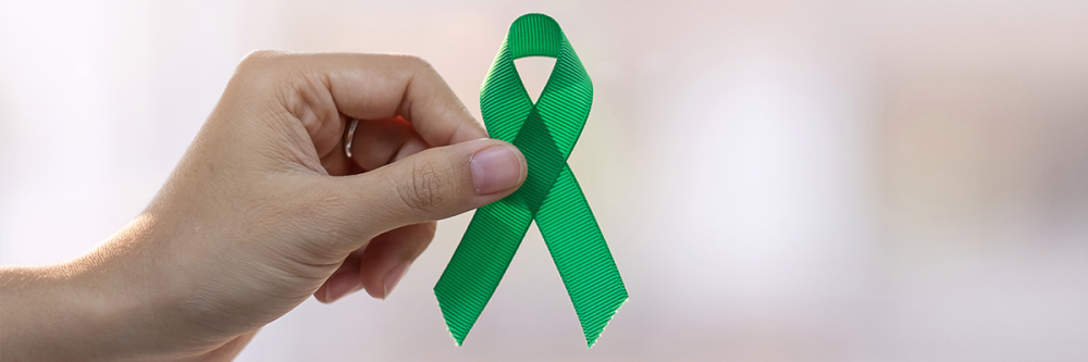 hand-holding-a-green-ribbon-for-Mental-Health-Month-awareness