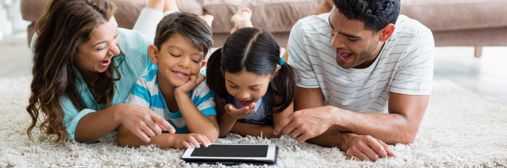 family-laughing-and-watching-tablet