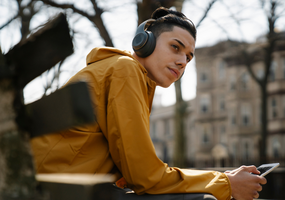 Teenager with headphones sitting on a bench