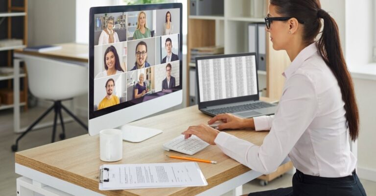 A women at a computer hosting a virtual meeting with a spreadsheet open on her second screen