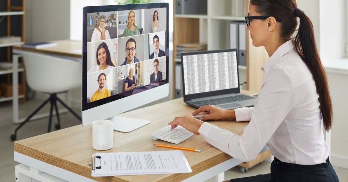 A women at a computer hosting a virtual meeting with a spreadsheet open on her second screen