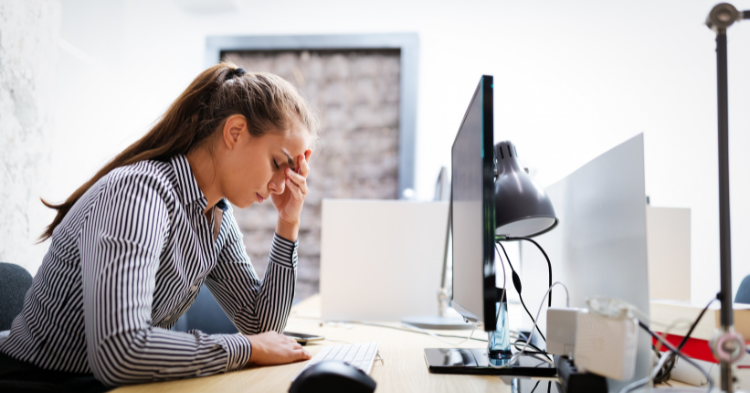 Woman at desk looking tired